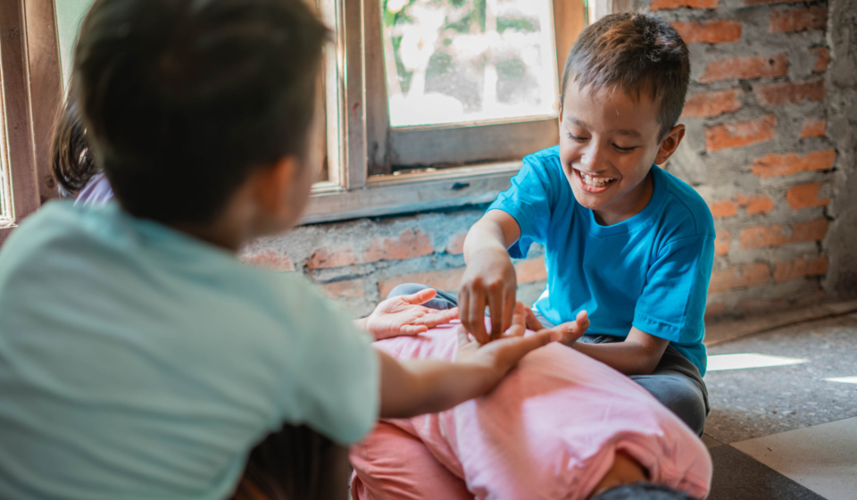 asian boy smiling while playing classic traditional indonesian games